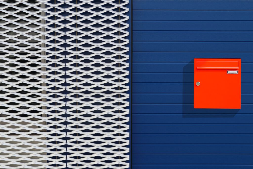 Ein roter Briefkasten an einer blauer Wand