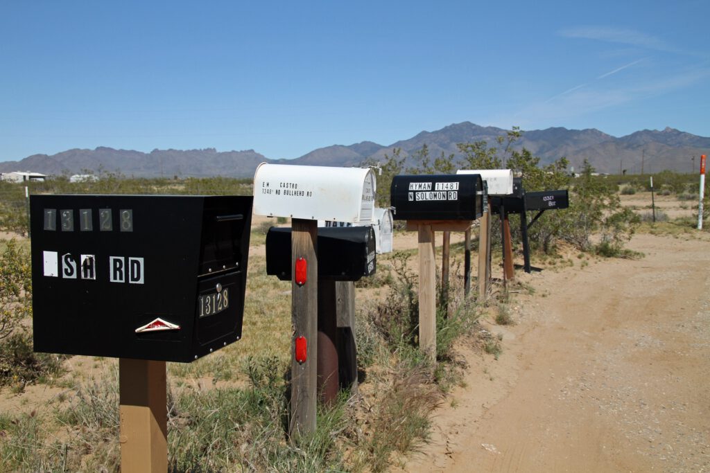 Eine Reihe von amerikanischen Briefkästen an einer sandigen Straße