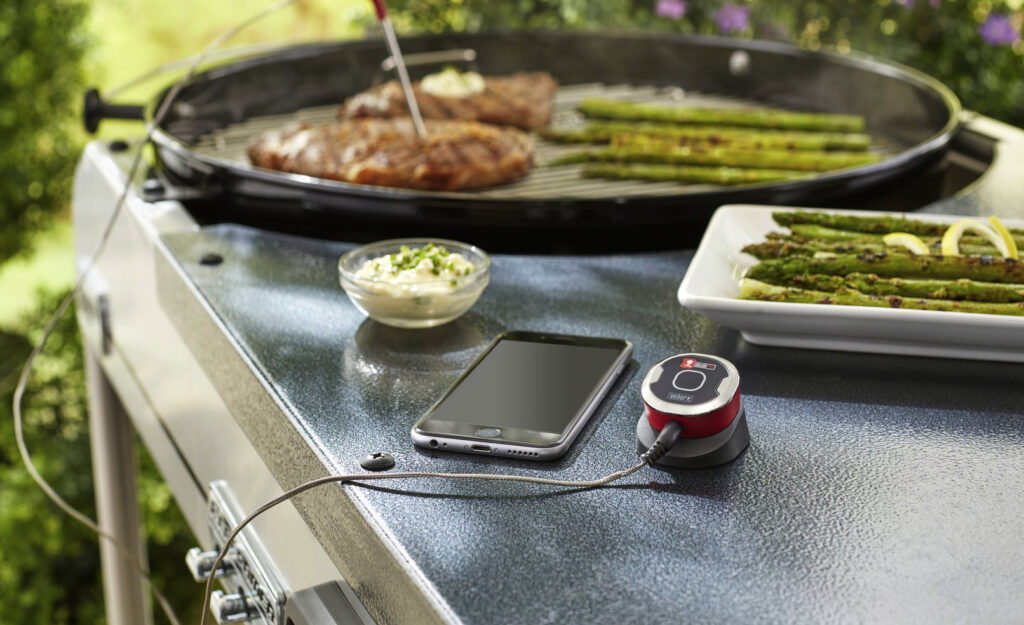 Ein Fleischthermometer mit Handy auf Tisch